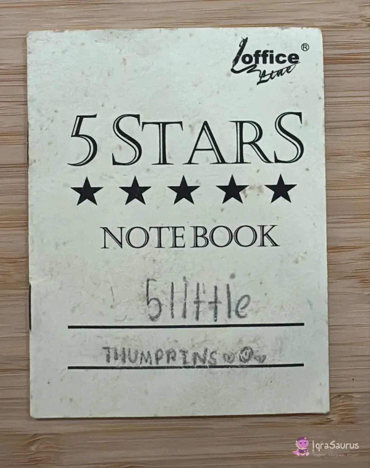 The small notebook cover with the title written by hand and tiny smiley faces.
