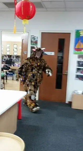 A performer in a Gruffalo costume walking into the library room