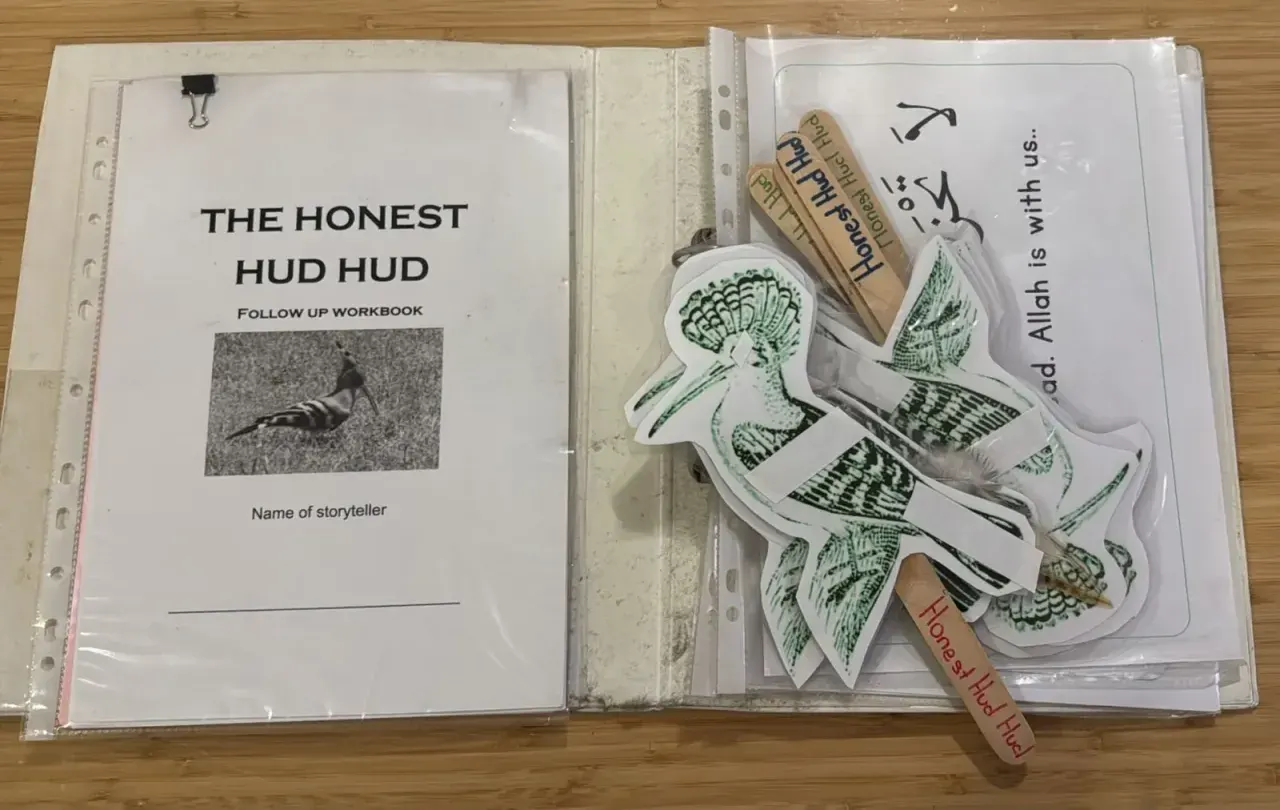The Honest Hudhud folder with the follow-up workbook, puppets and a verse card